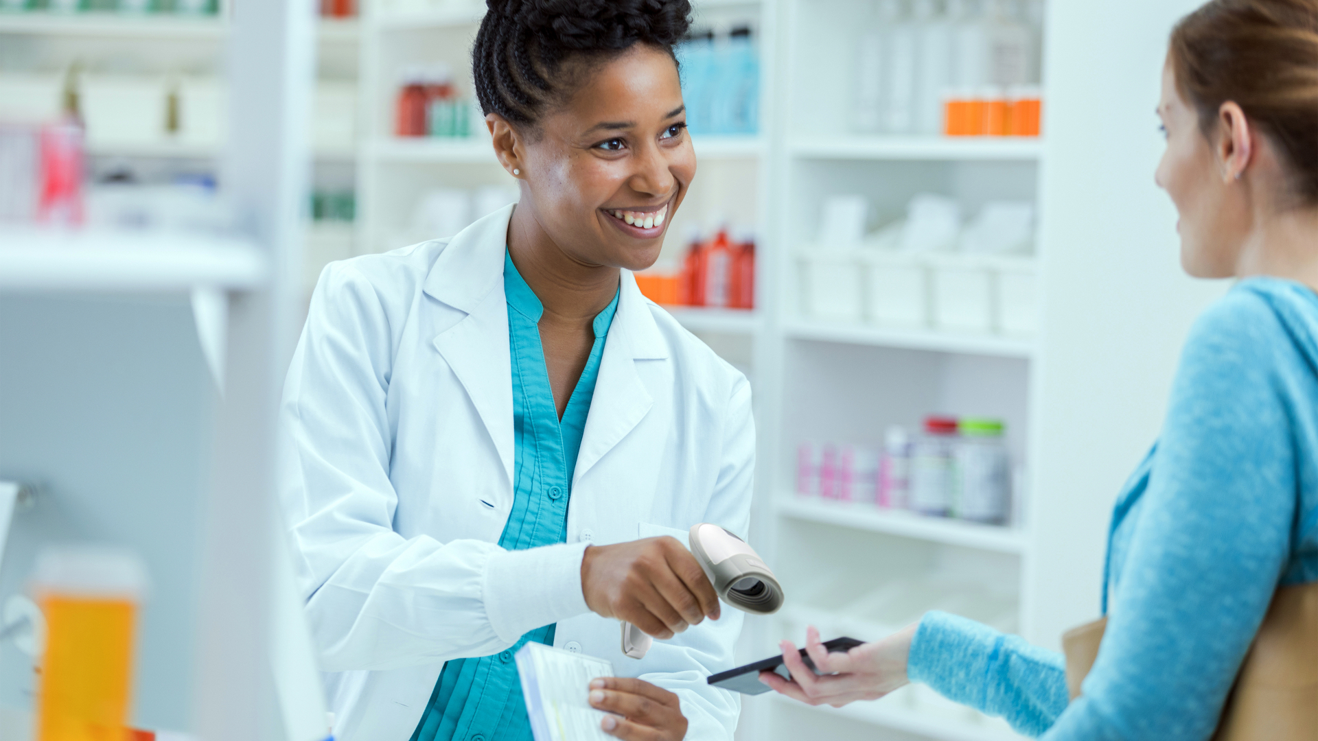 Picture of a woman in a pharmacy using the HR32 Handheld Barcode Scanner to scan a code on a patient's phone.